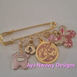 دبوس نازل منه الاسم و لعبتين ملونين و رجل صغيره و حجر